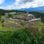 Ausflug zu Adlerarena Burg Landskron - Luftaufnahme mit Burgruine und Mittagskogel - Karawanken im Hintergrund