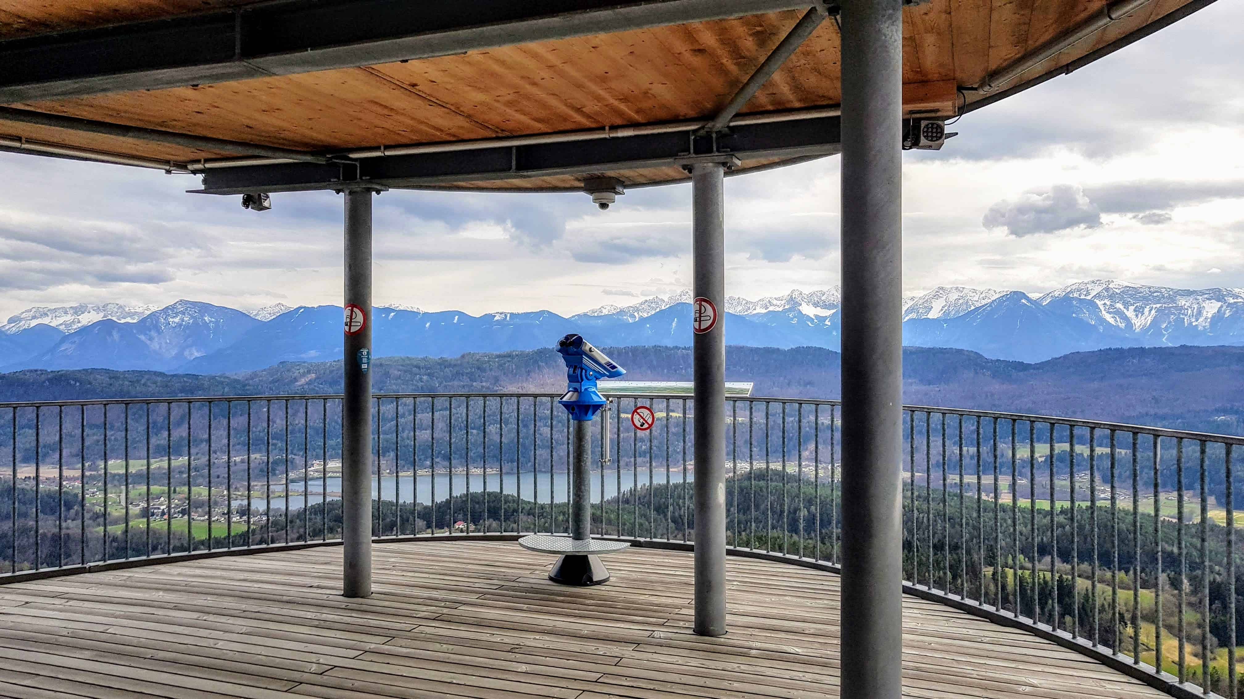 Aussichtsplattform am Pyramidenkogel in Kärnten. Blick auf Keutschacher See und Karawanken. Fernrohr auf Plattform.