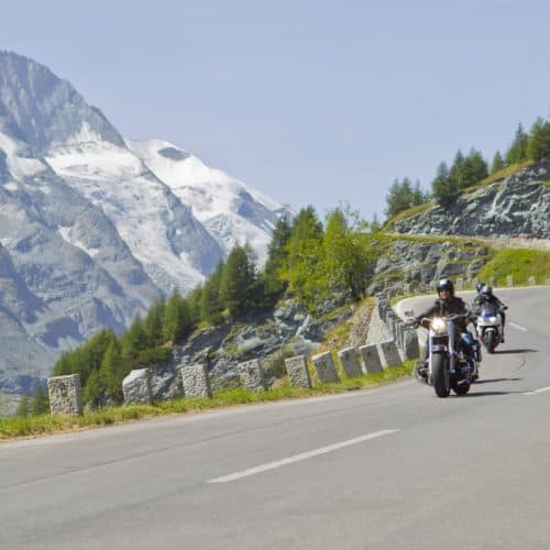 Motorradfahrer entlang der Großglockner Hochalpenstraße mit Großglockner im Hintergrund. Schönste Panoramastraße in Österreich.