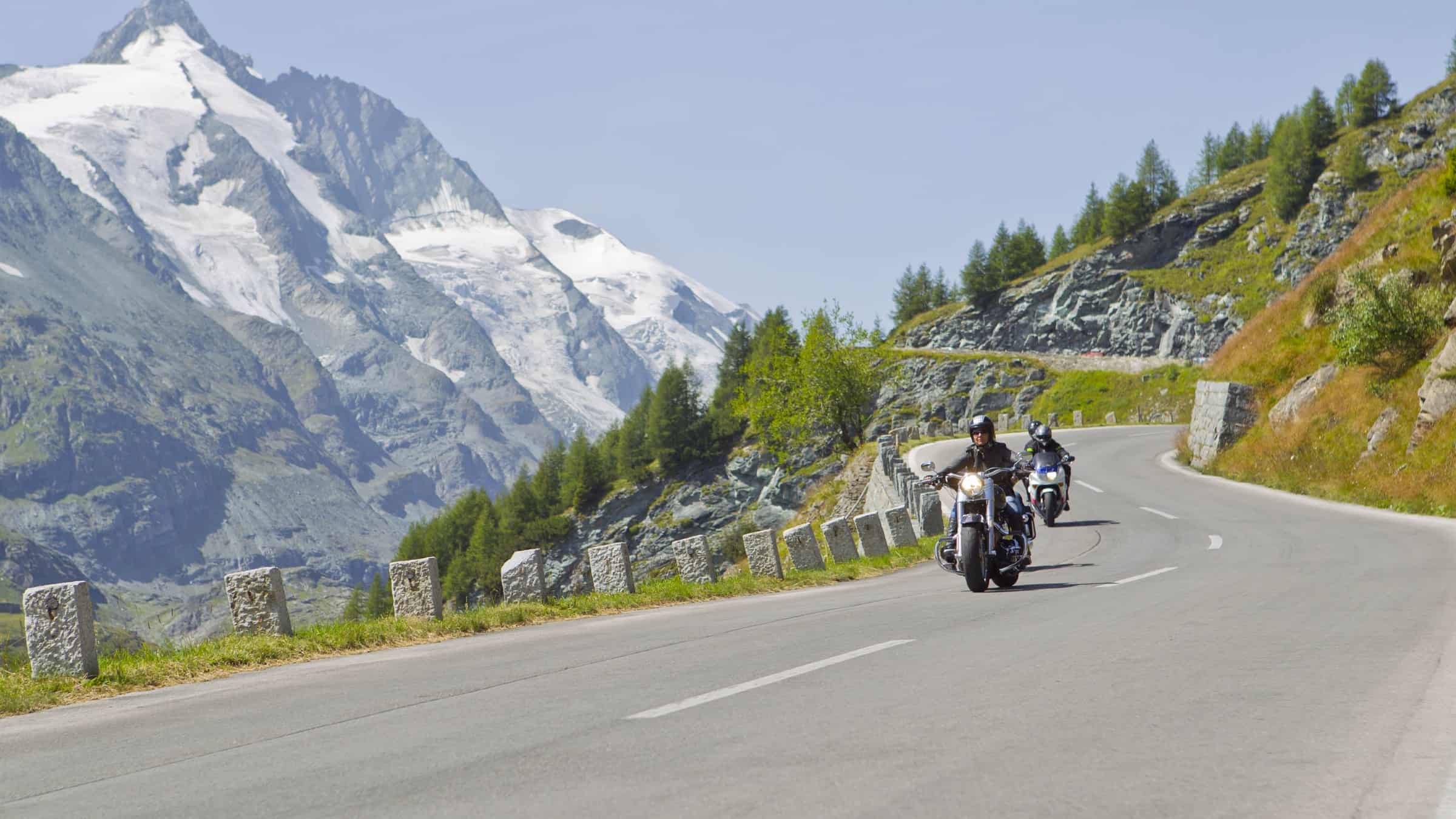 Motorradfahrer entlang der Großglockner Hochalpenstraße mit Großglockner im Hintergrund. Schönste Panoramastraße in Österreich.