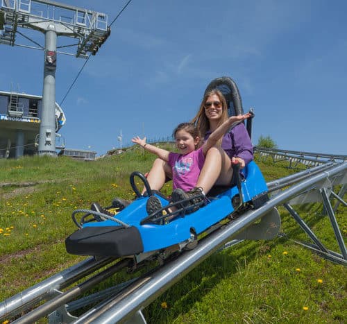 Kind mit Eltern auf der Sommerrodelbahn Nocky Flitzer auf der Turracher Höhe in Kärnten und Steiermark in Österreich