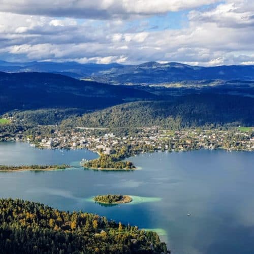 Aussicht am Pyramidenkogel auf Wörthersee, Pörtschach, Kapuzinerinsel & Kärntner Nockberge im Herbst. Sehenswürdigkeiten Österreich