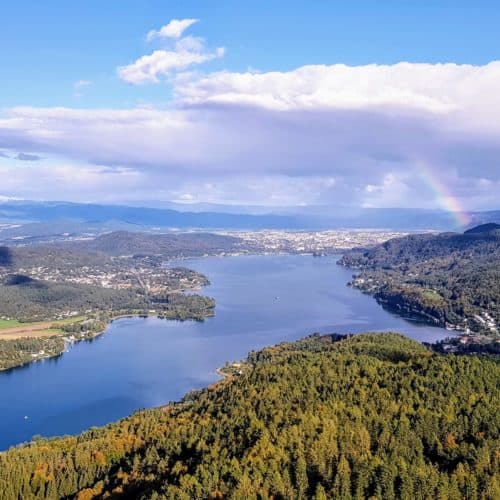 Schlechtwetter Ausflugsziel in Kärnten - Pyramidenkogel am Wörthersee im Herbst mit entstehenden Regenbogen über Klagenfurt in Österreich