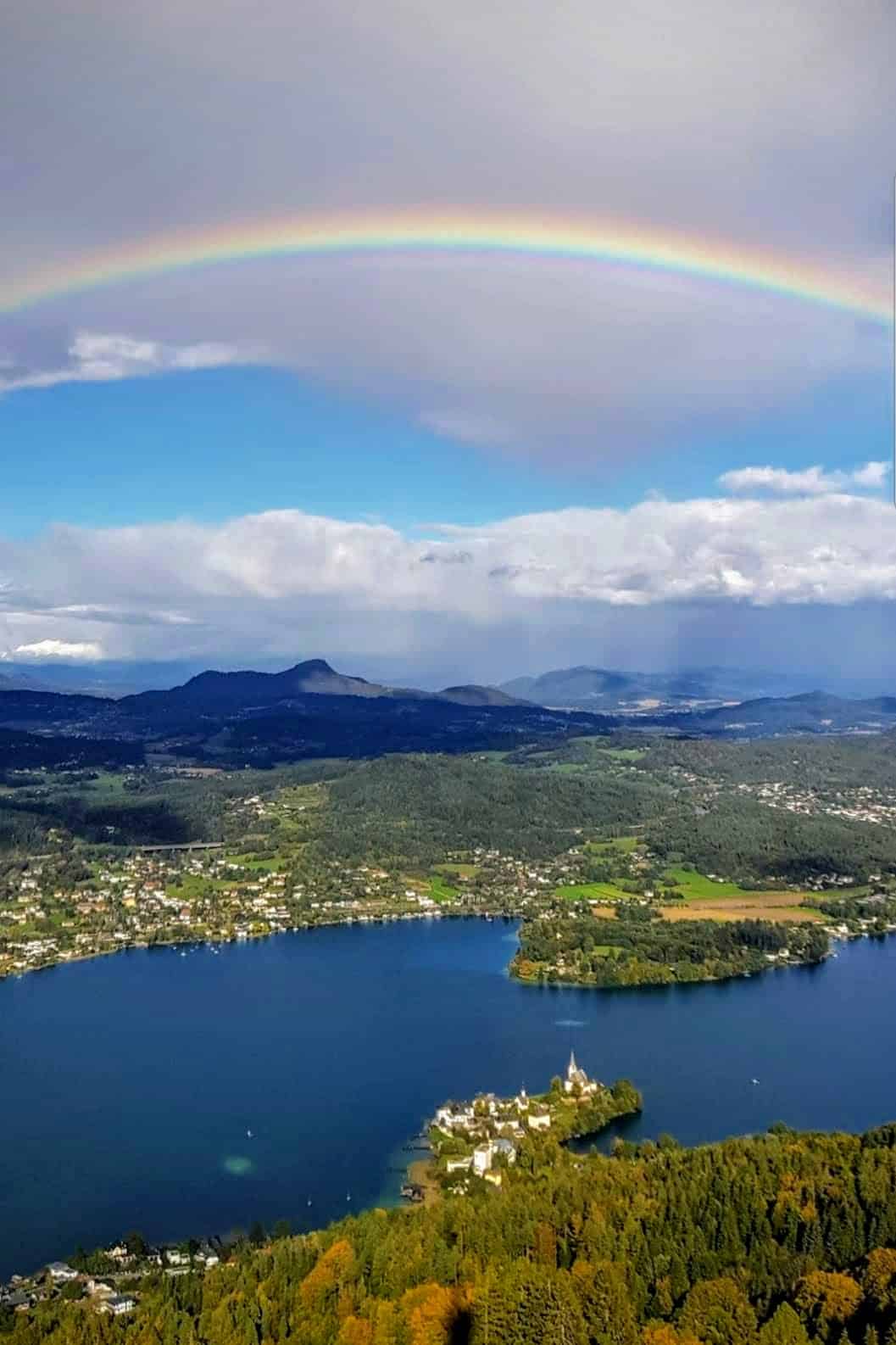 Regenbogen über Maria Wörth am Wörthersee in Kärnten. Blick vom Pyramidenkogel - Ausflugsziel in Kärnten, Österreich.