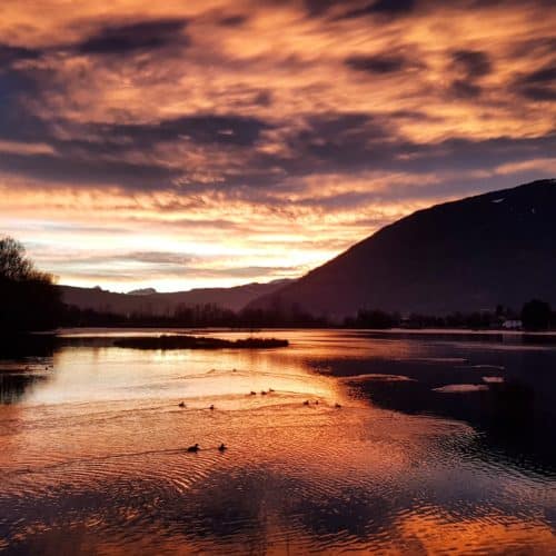 Abendstimmung mit Wolkenhimmel am Ossiacher See in der Region Villach mit Blick auf Gerlitzen, Dobratsch und Bleistätter Moor.