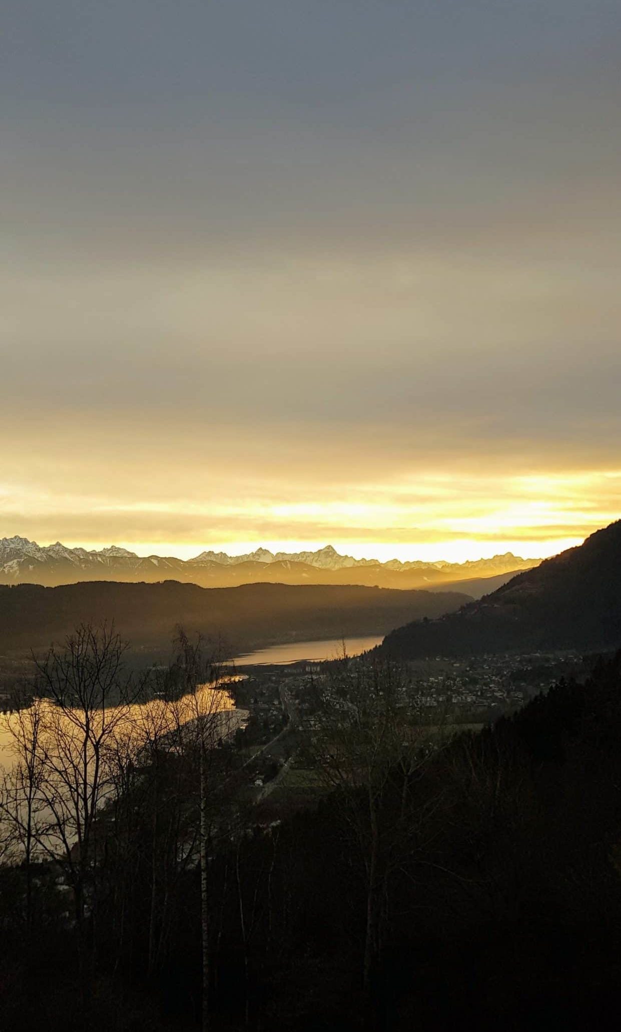 Panorama mit Sonnenuntergang am Wanderweg über den Ossiacher See und Steindorf in der Region Villach in Kärnten, Österreich.