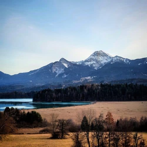 Winter in Kärnten in der Region Villach mit Blick auf Faaker See, Mittagskogel und Karawanken. Radtour um den See.