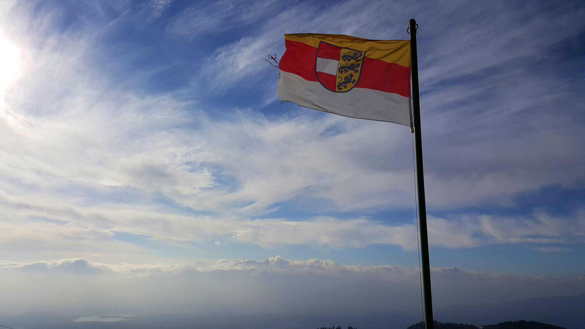 Kärntner Flagge auf Gerlitzen Alpe im Winter bei Winterwanderung abseits der Pisten. Winteraktivitäten in Österreich.