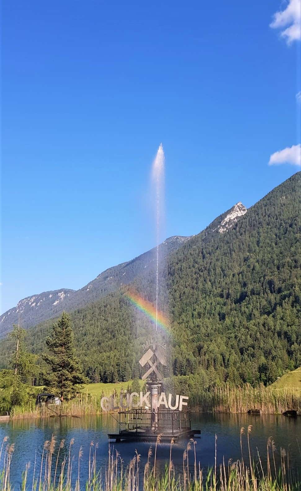 Glück auf Brunnen mit Regenbogen vor den Schaubergwerken Terra Mystica & Montana in Bad Bleiberg, Nähe Villach in Kärnten - Österreich.