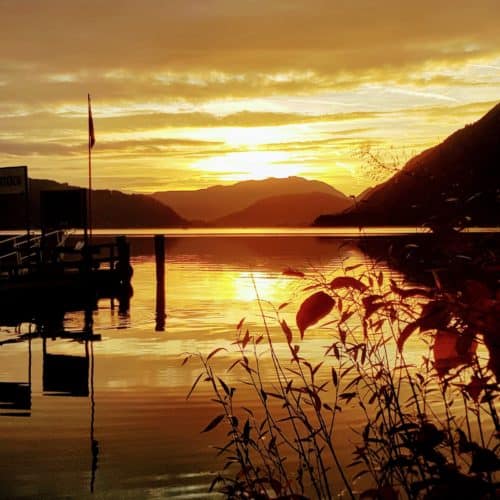 Ossiacher See Schifffahrt - Anlegestelle in Ossiach mit Sonnenuntergang. Ausflugsziel in Österreich, Kärnten.