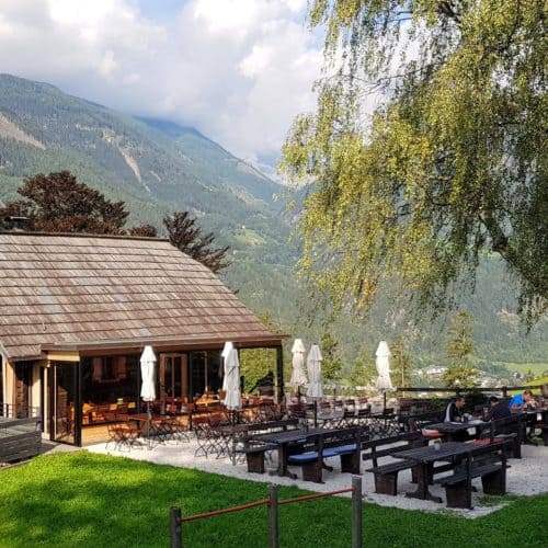 Terrasse der Launsberg Hütte. Slow-Food-Betrieb in Obervellach mit modernem Zubau. Ausflugsziel & Sehenswürdigkeit in Kärnten.