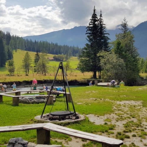 Kinder und Erwachsene am Kinderspielplatz bei Fluss in Mallnitz, Start Seebachtal Wanderungen. Ausflugstipp für Kärnten mit Kindern.