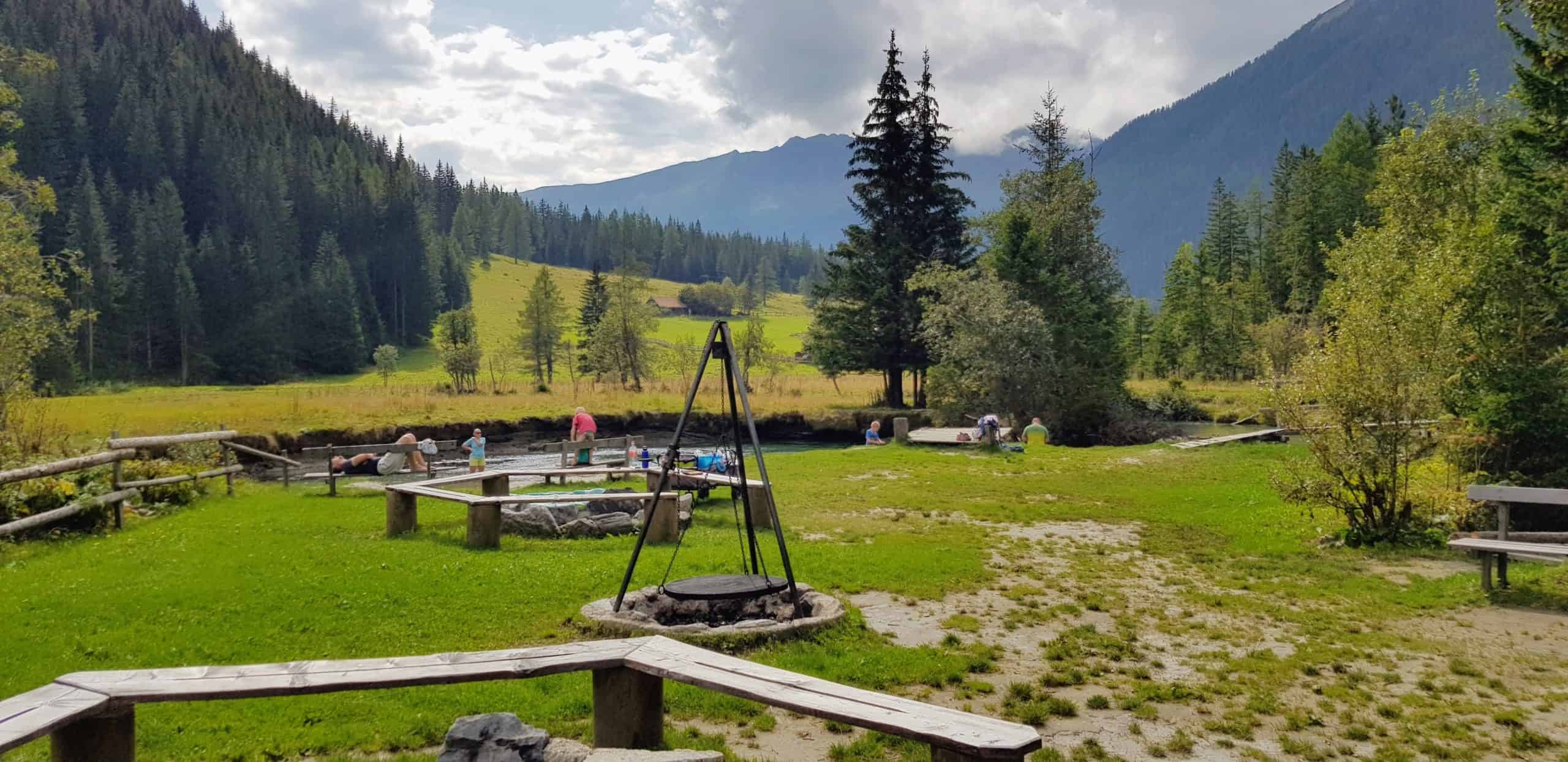 Kinder und Erwachsene am Kinderspielplatz bei Fluss in Mallnitz, Start Seebachtal Wanderungen. Ausflugstipp für Kärnten mit Kindern.