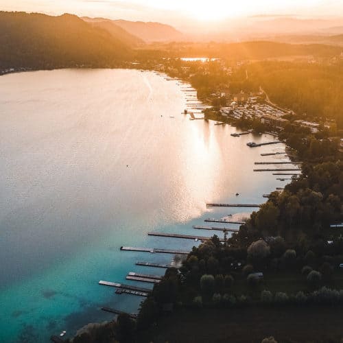 Sonnenuntergang am Klopeinersee in Kärnten. Luftaufnahme mit Orten, den See und der Landschaft bei Urlaub in Österreich.