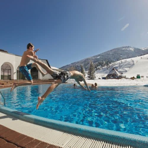 Thermalbad Römerbad im Winter mit Skipiste neben Bad. Therme in Bad Kleinkirchheim - Kärnten.