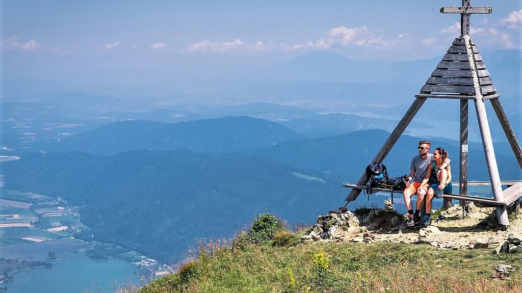 Geheimtipps & schöne Orte in Kärnten: Wanderer auf der Gerlitzen Alpe mit Blick auf Ossiacher See, Bleistätter Moor & Karawanken