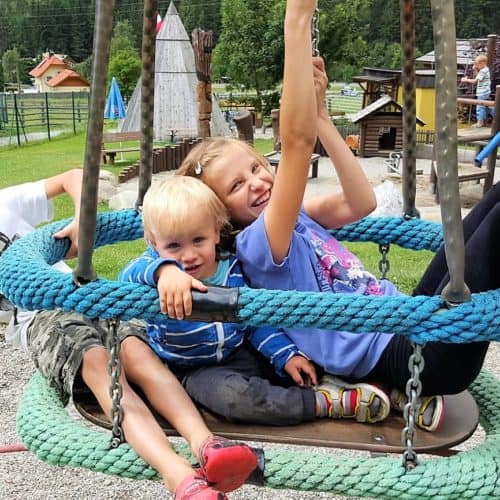 Kinder auf Spielgerät im Outdoor Kinderspielplatz im Maltatal beim Fallbach, Kärntens höchster Wasserfall